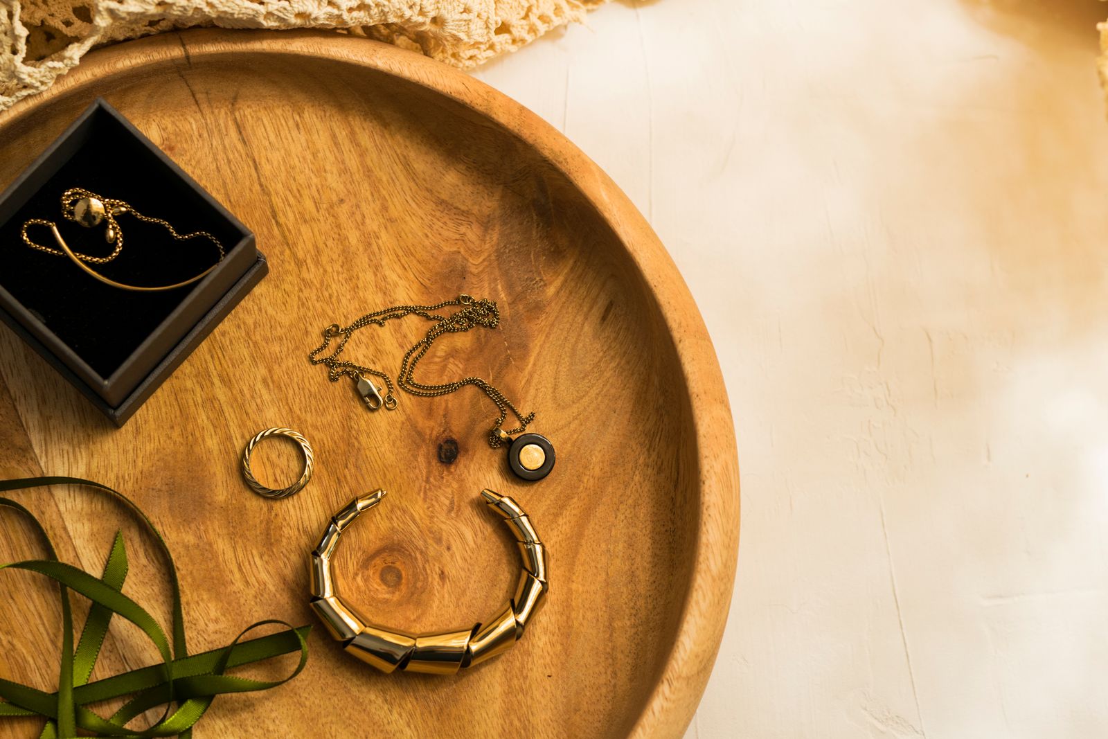 Gold jewellery on a wooden tray